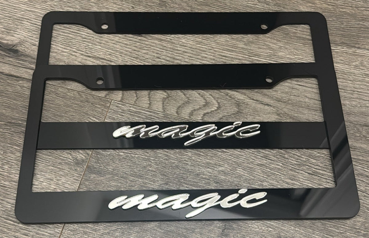 Black license plate frame with 'magic' text on a wooden floor.